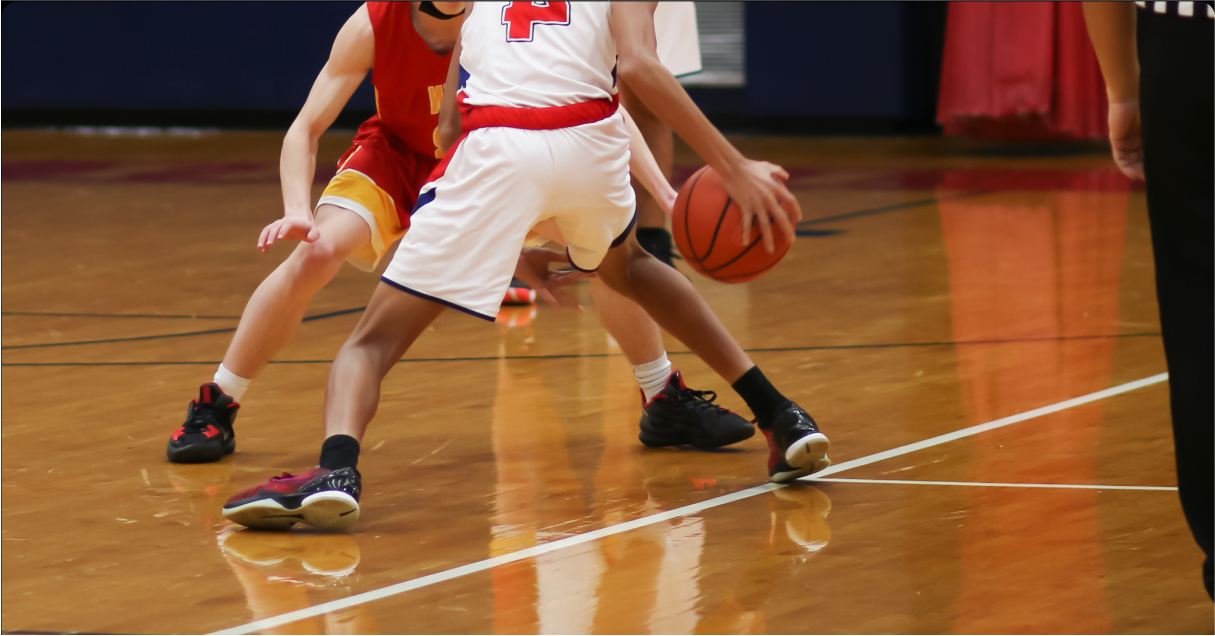 chasingdreams_wide A high school basketball player dribbles the ball in front of a defender