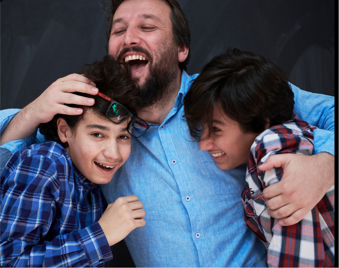 familyactivities A smiling father hugs his two sons