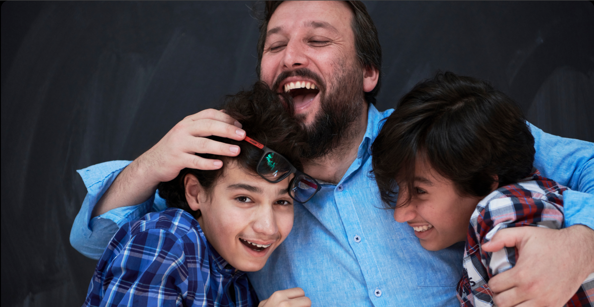 familyactivities_wide A smiling father hugs his two sons