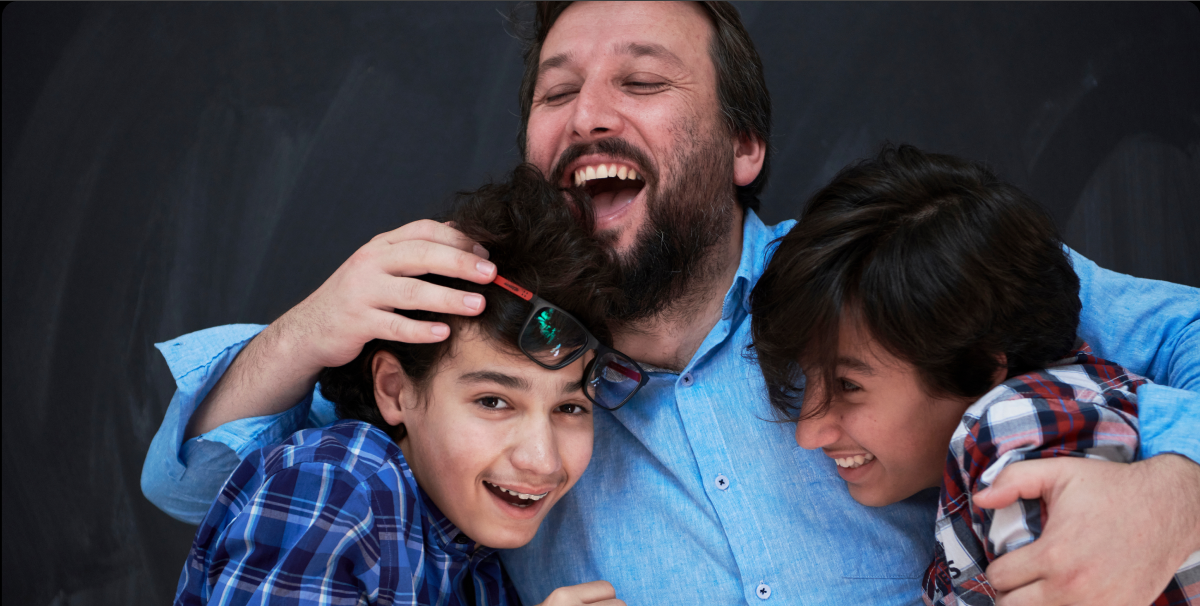 familyactivities_wide A smiling father hugs his two sons
