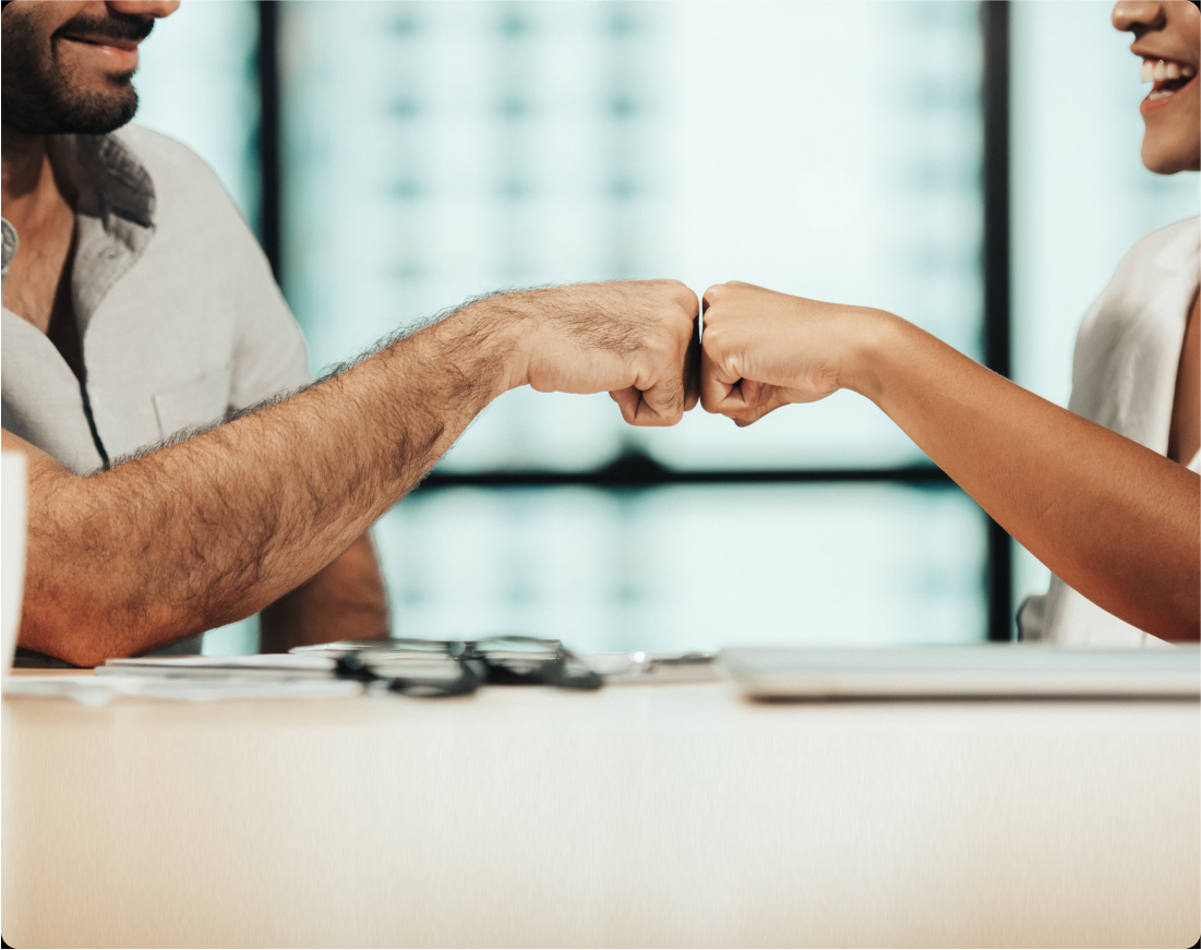 partners_empoweryouthfutures_stock_cropped A man and a woman bump fists in a corporate setting